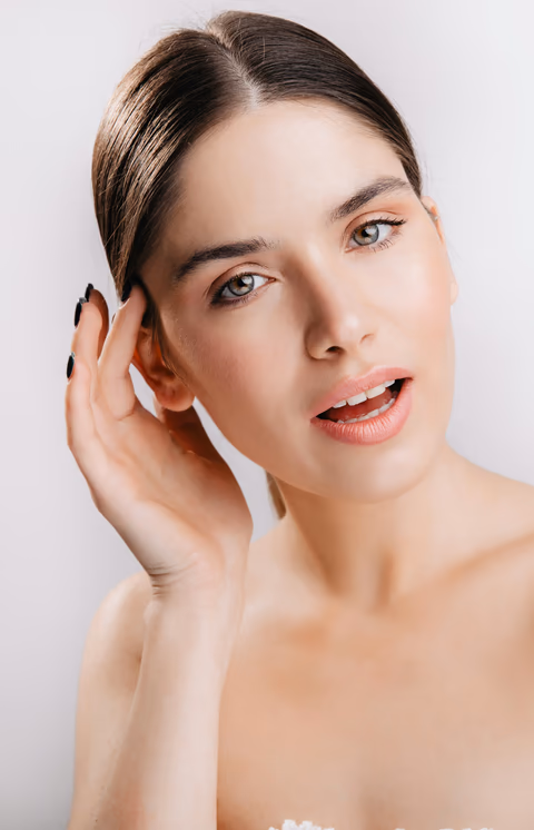 A woman touching her glowing cheek
